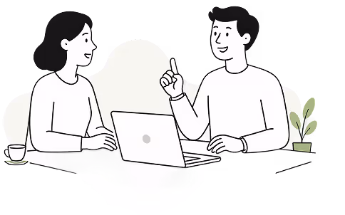Un homme et une femme discutent devant un ordinateur portable sur une table avec une plante.