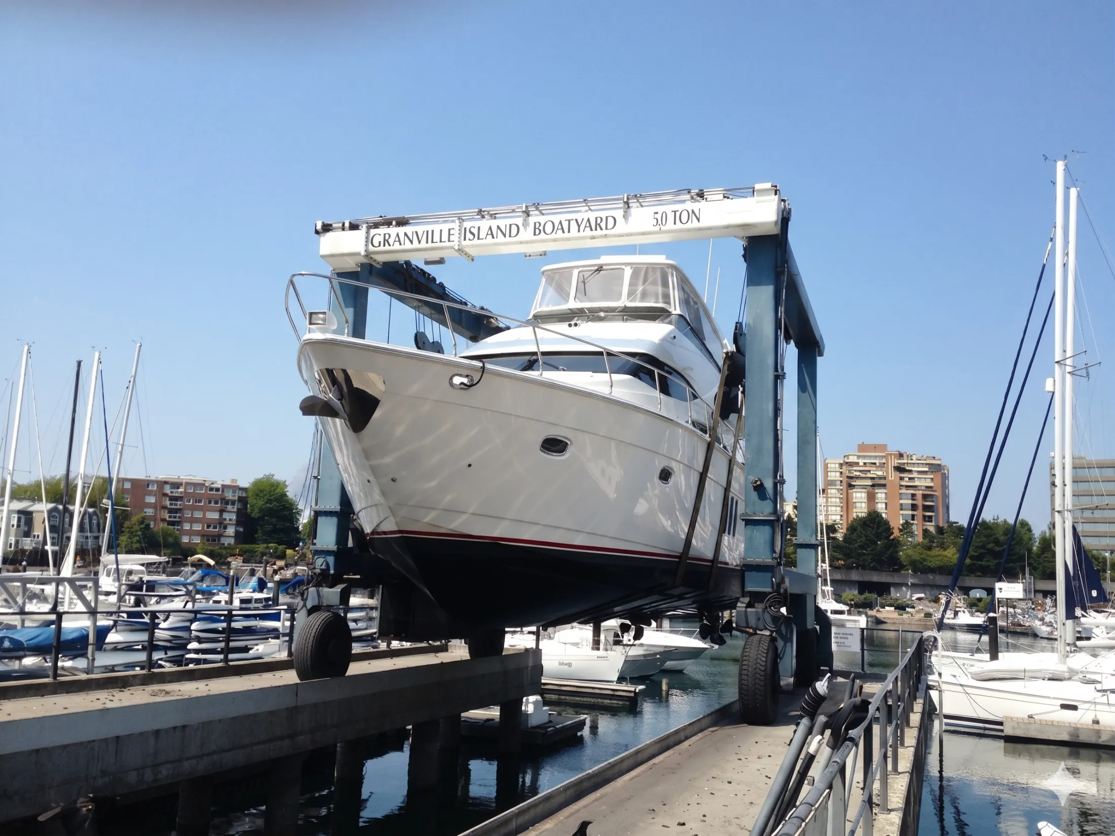 Vessel being lifted by travel lift at Granville Island Boatyard for round trip haul-out Vancouver