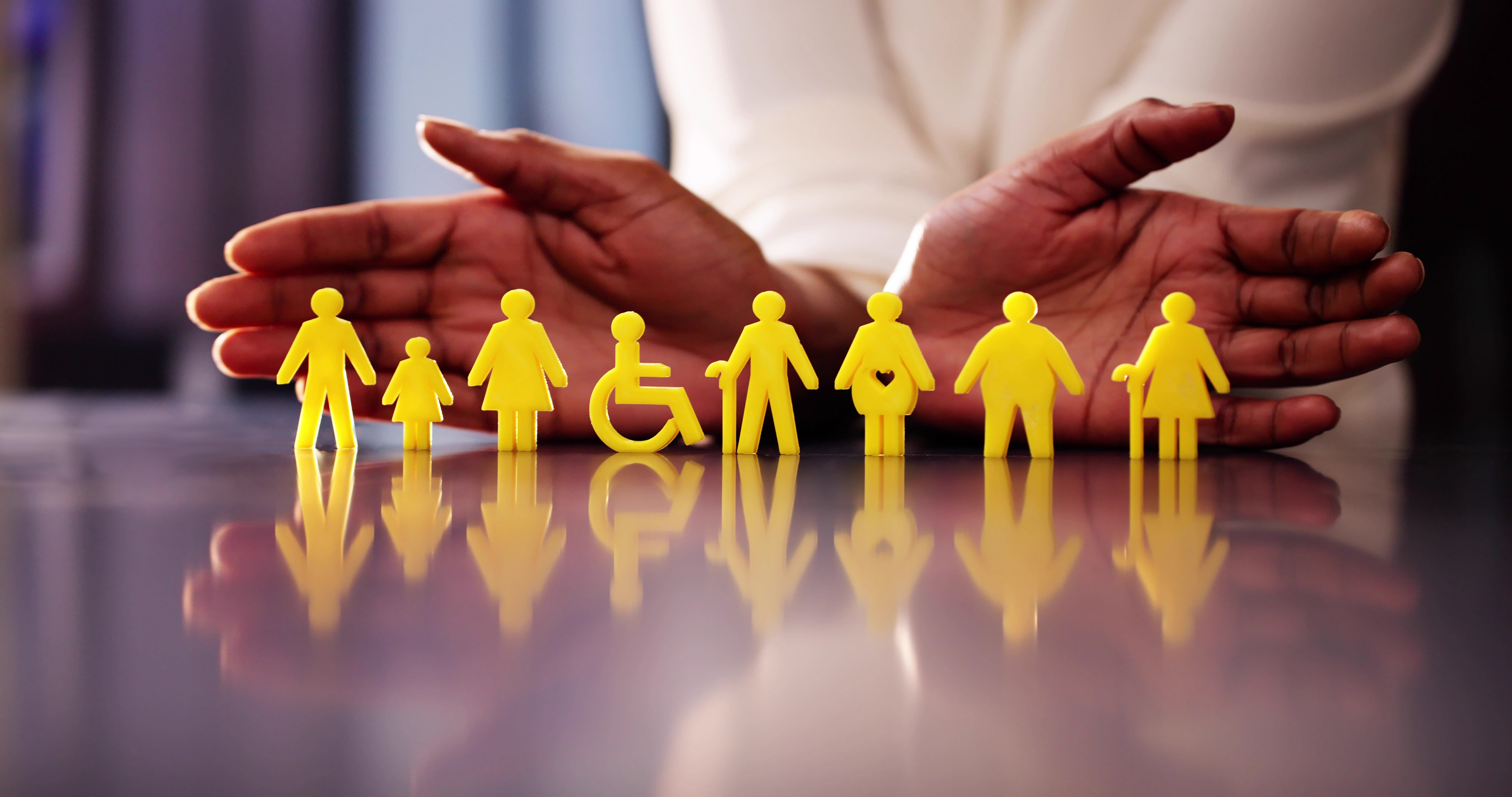 Hands protecting yellow figures representing diverse people, including child, disabled, elderly, and pregnant.