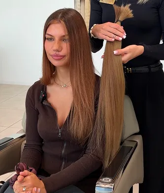 Stylistka dobiera pasmo do przedłużania obok klientki