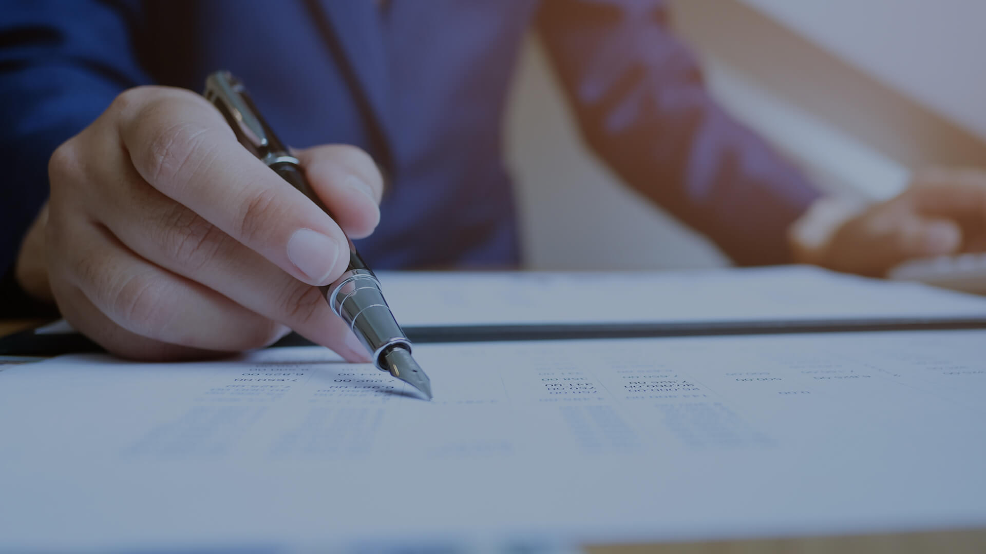 Close-up of a person signing a document, representing AGB Insurance's personal lines coverage
