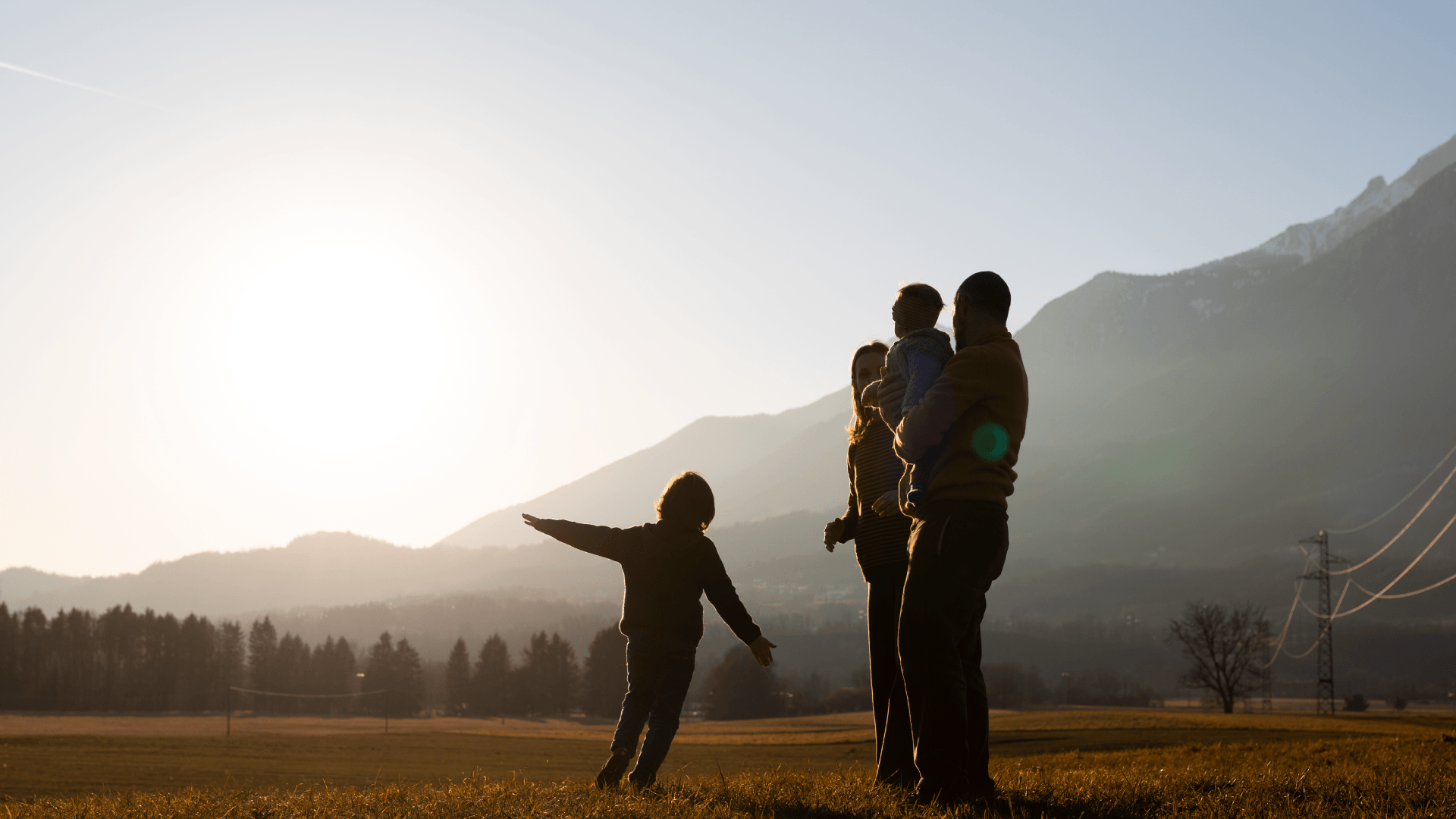 Family silhouette on a hillside at sunrise, representing life and health protection with AGB Insurance