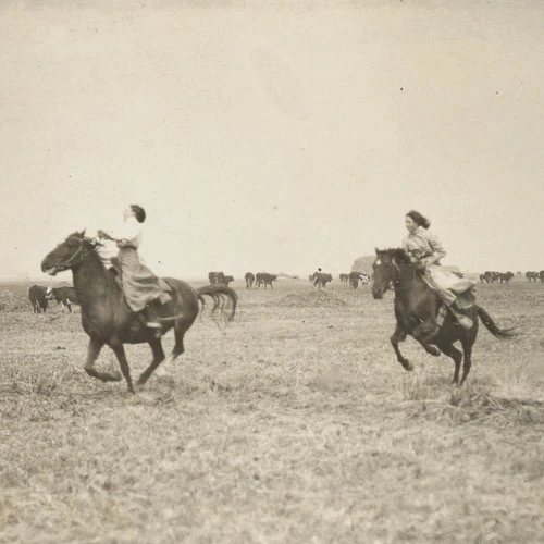Vintage image of two women riding horseback and galloping through a field.