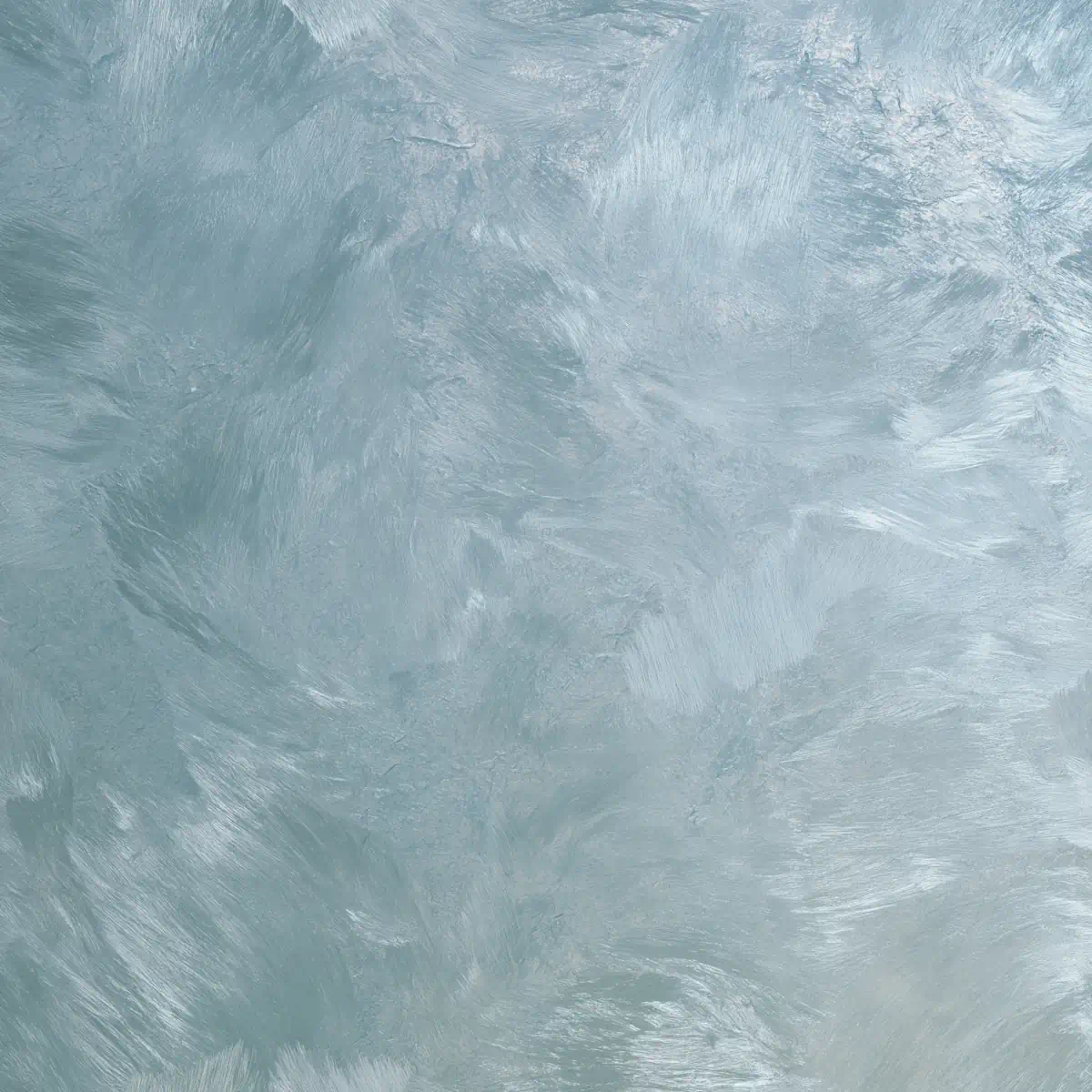 Een vlakke wand met Silk / Velvetlook (Zijde en Fluweel) sierpleister. De naadloze afwerking glanst met metallische pigmenten в lichte champagne и zilver-blauwe tinten, и speelt subtiel met het licht door Strakua.