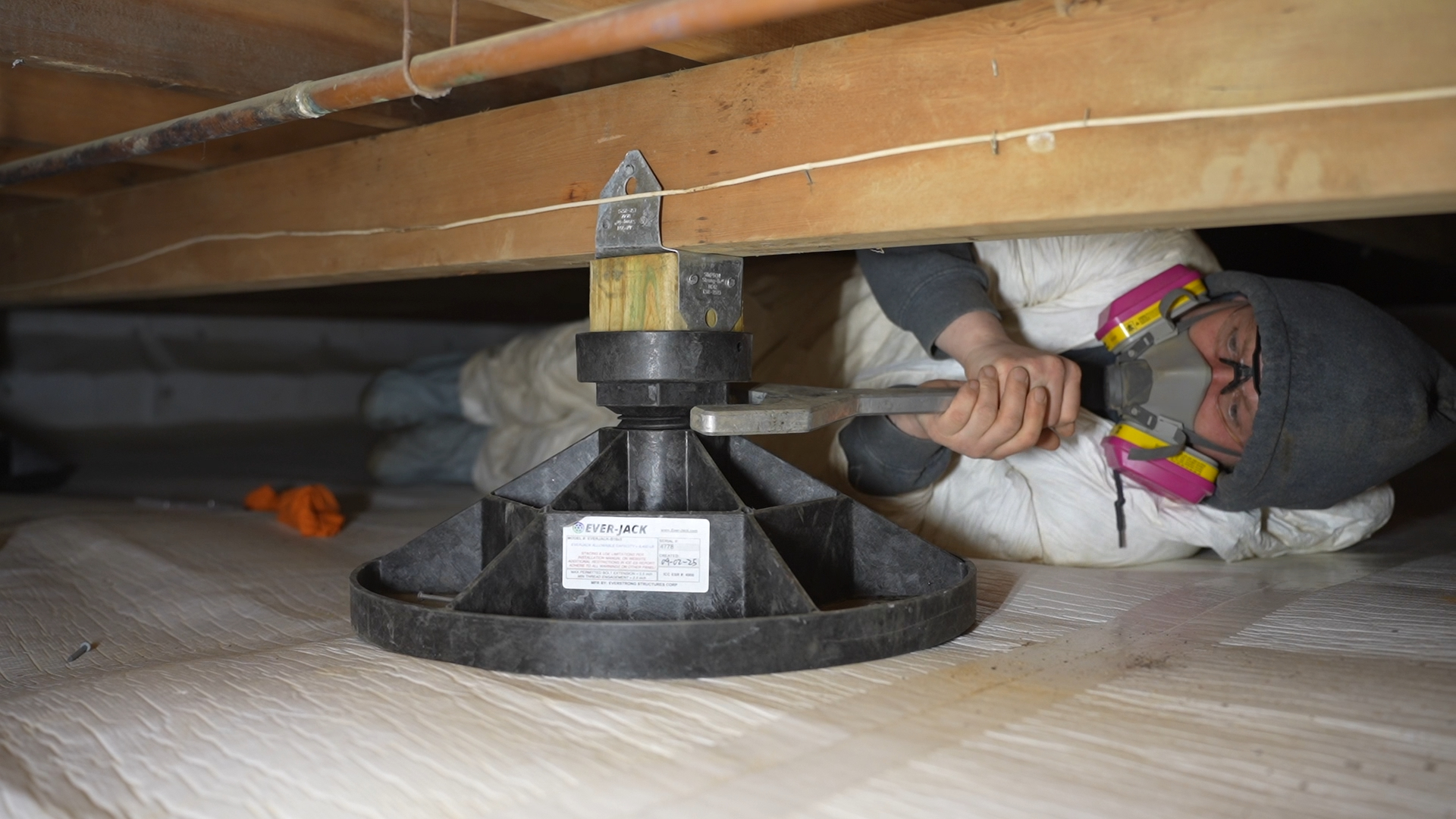 Tech installing a crawl space jack post