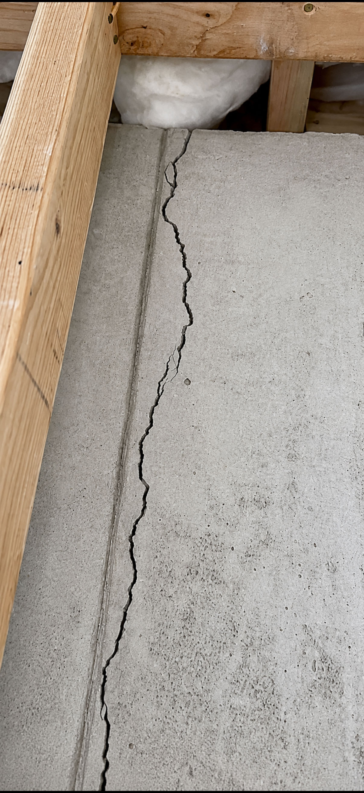 Worker prepping a basement block wall for crack repair