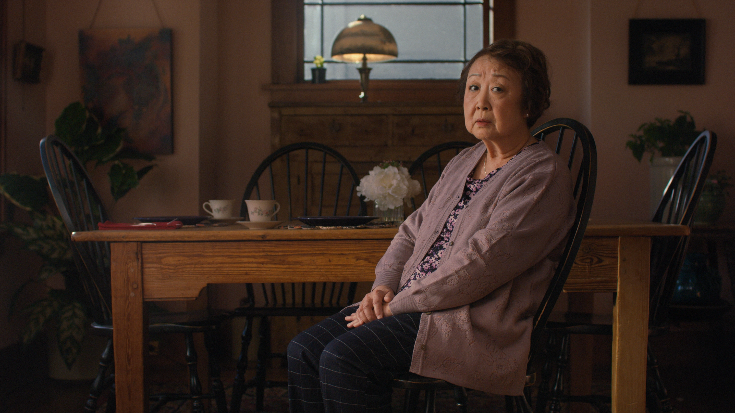 An Asian grandmother seated at home.