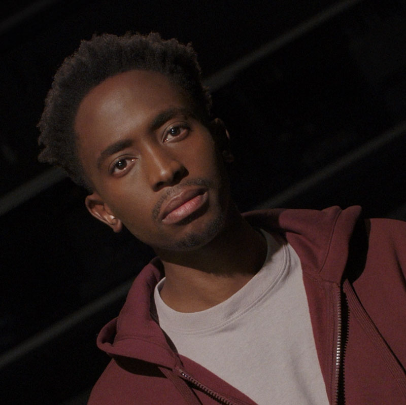 A Black teenager in an auditorium.