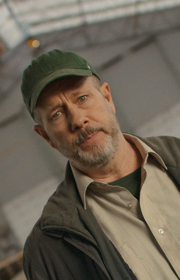 A white, middle-aged farmer in a farm building.