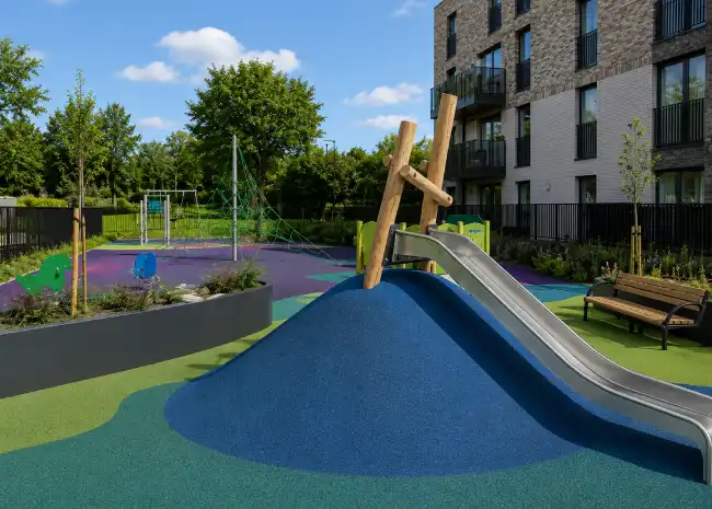 Colorful playground with a slide and climbing structure at resn bound outdoor recreational area.