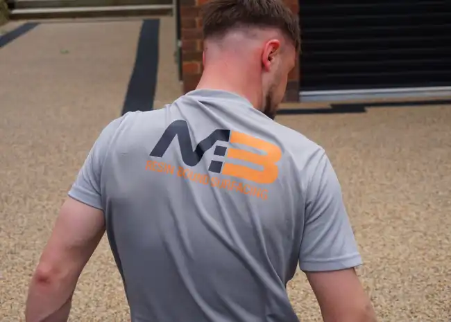 Man from behind wearing a gray shirt with 'MB Resin Cloud Surfacing' printed on the back.