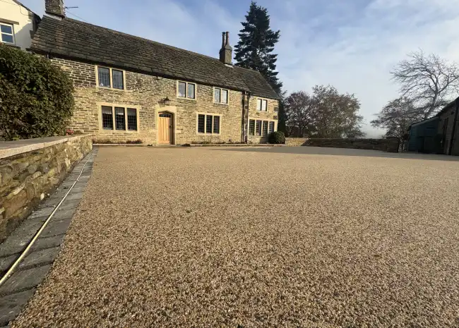 Stone house with wooden door and gravel driveway at resn bound property exterior.
