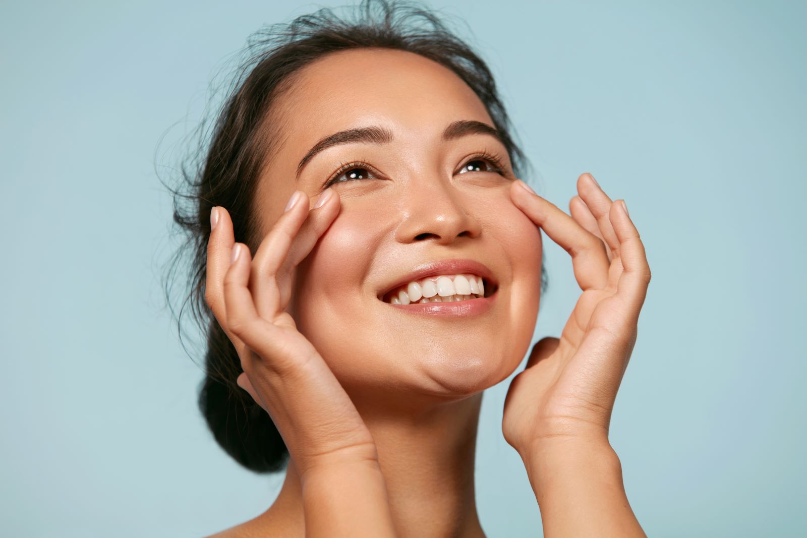 asian woman touching cheeks smiling
