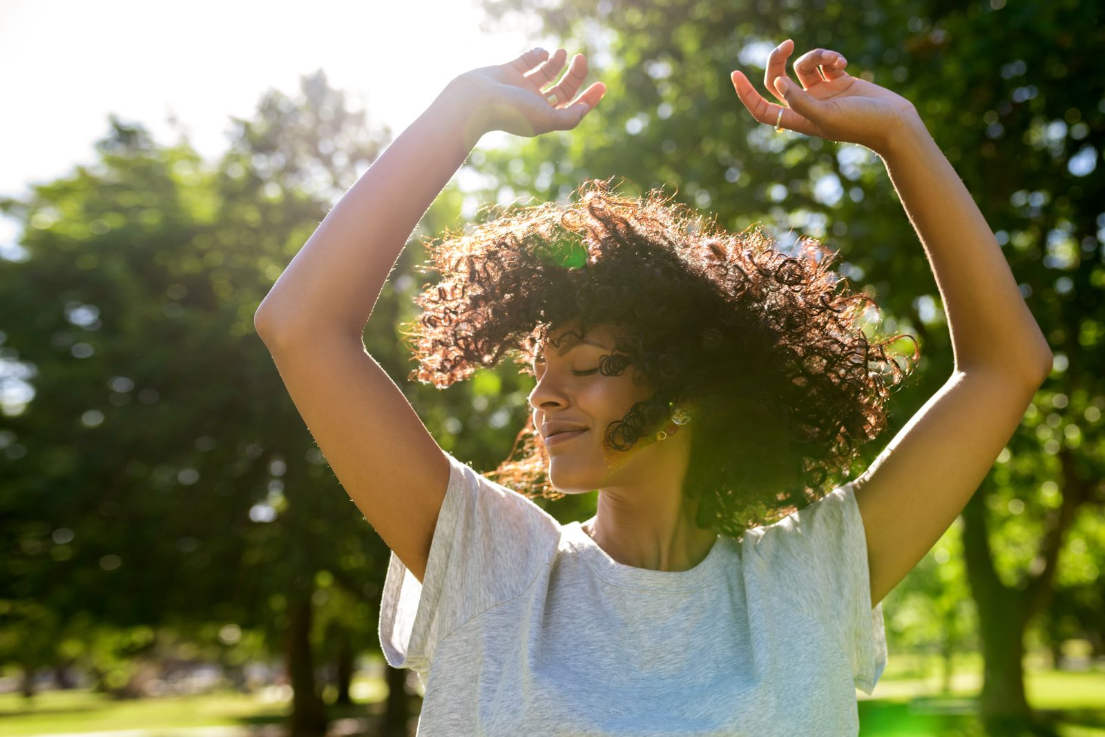 woman dancing in nature with her hands up