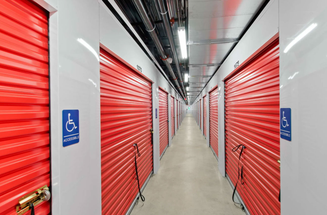 Pack N Stor East Fishkill NY Long corridor of storage units with red roll-up doors and accessible signs on some units.