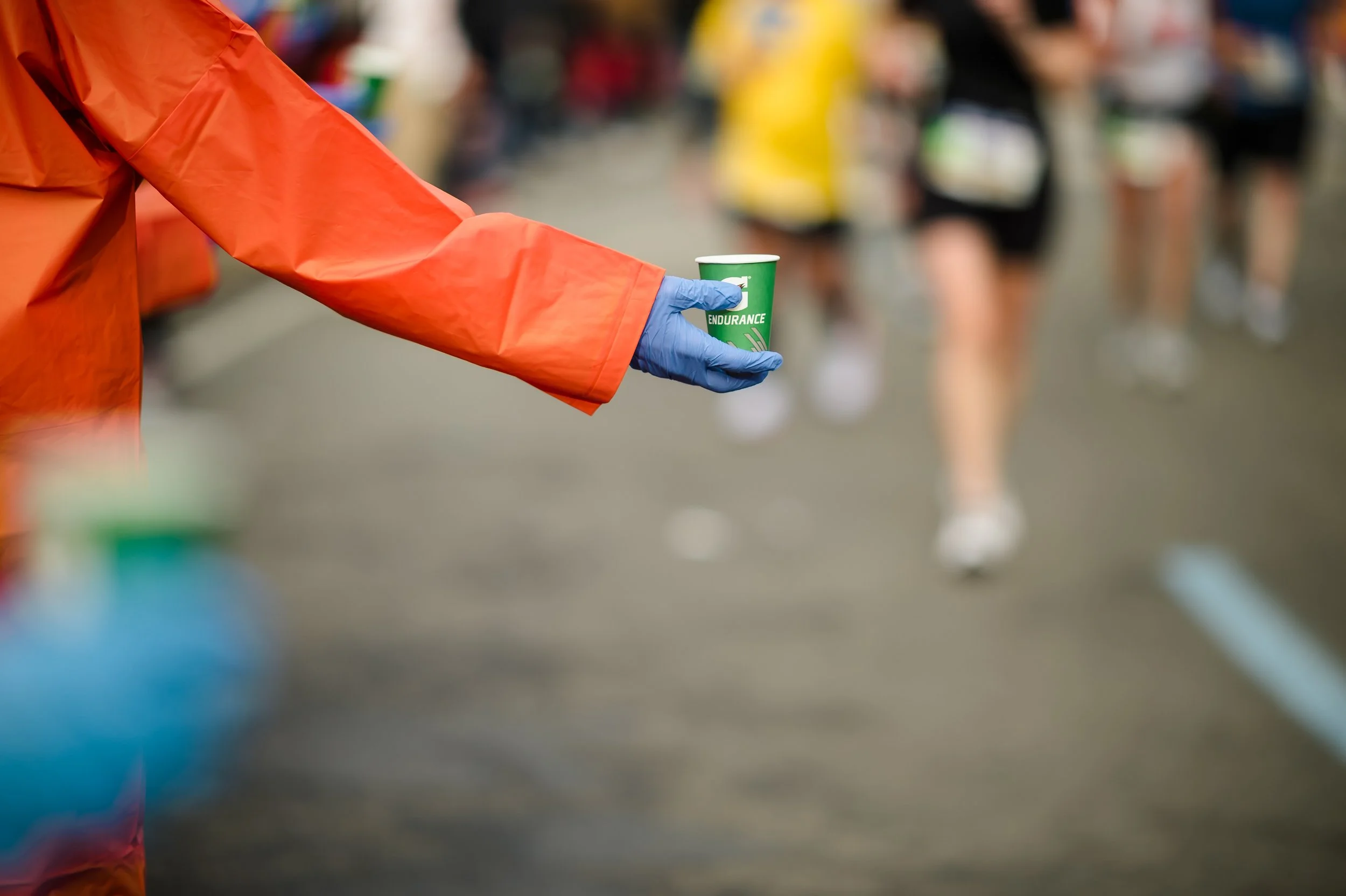 A volunteer handing out water at a New York Road Runners event