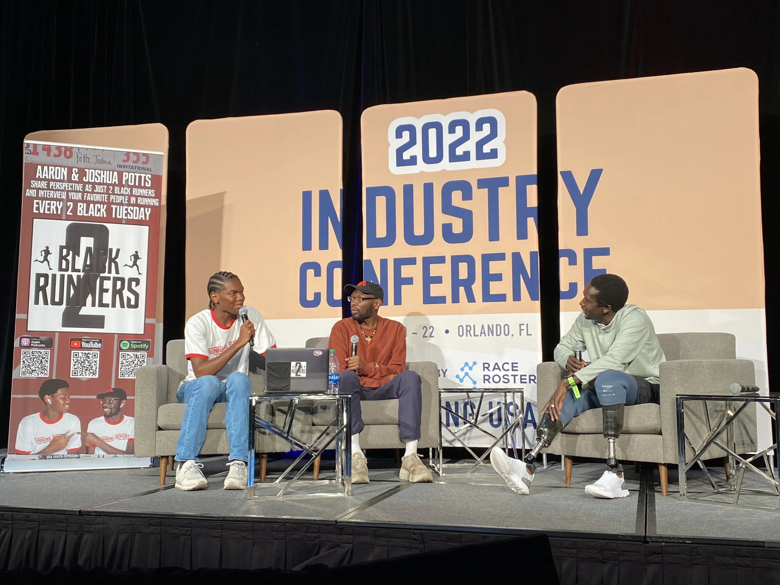 Joshua (left) and Aaron (center) Potts of the ‘Two Black Runners’ podcast interview double amputee world record holder Marko Cheseto (right) at the 2022 Running USA Industry Conference in Orlando, Florida.