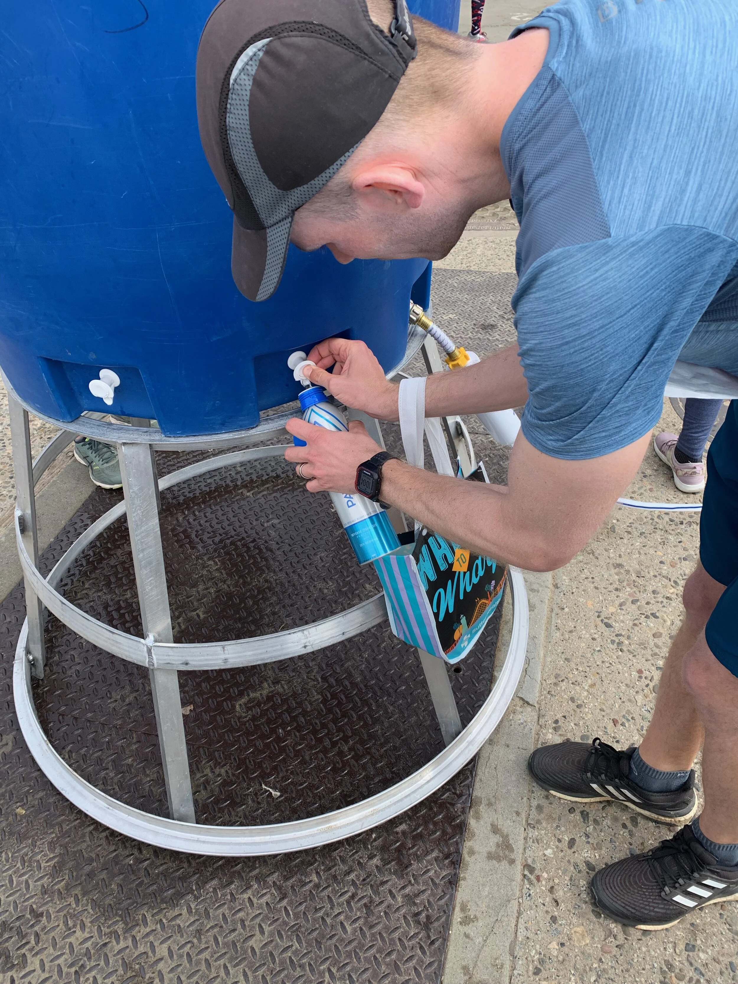 A runner using a reusable aluminum water bottle by PATHWATER during the 2019 Wharf to Wharf race