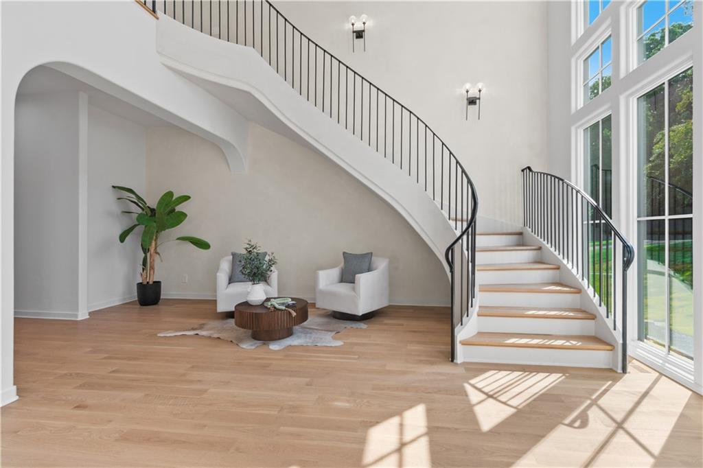 Curved staircase in two-story foyer of custom estate home