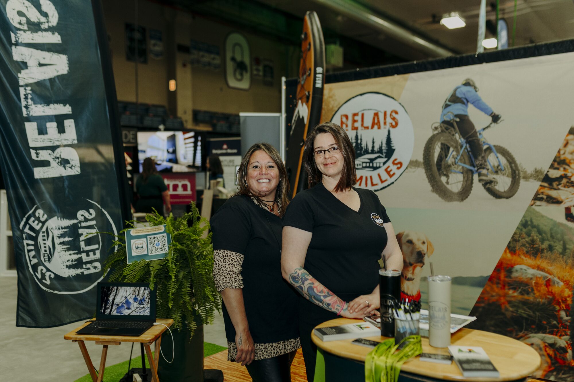 Exposantes souriantes à leur kiosque au Salon des commerçants 2025