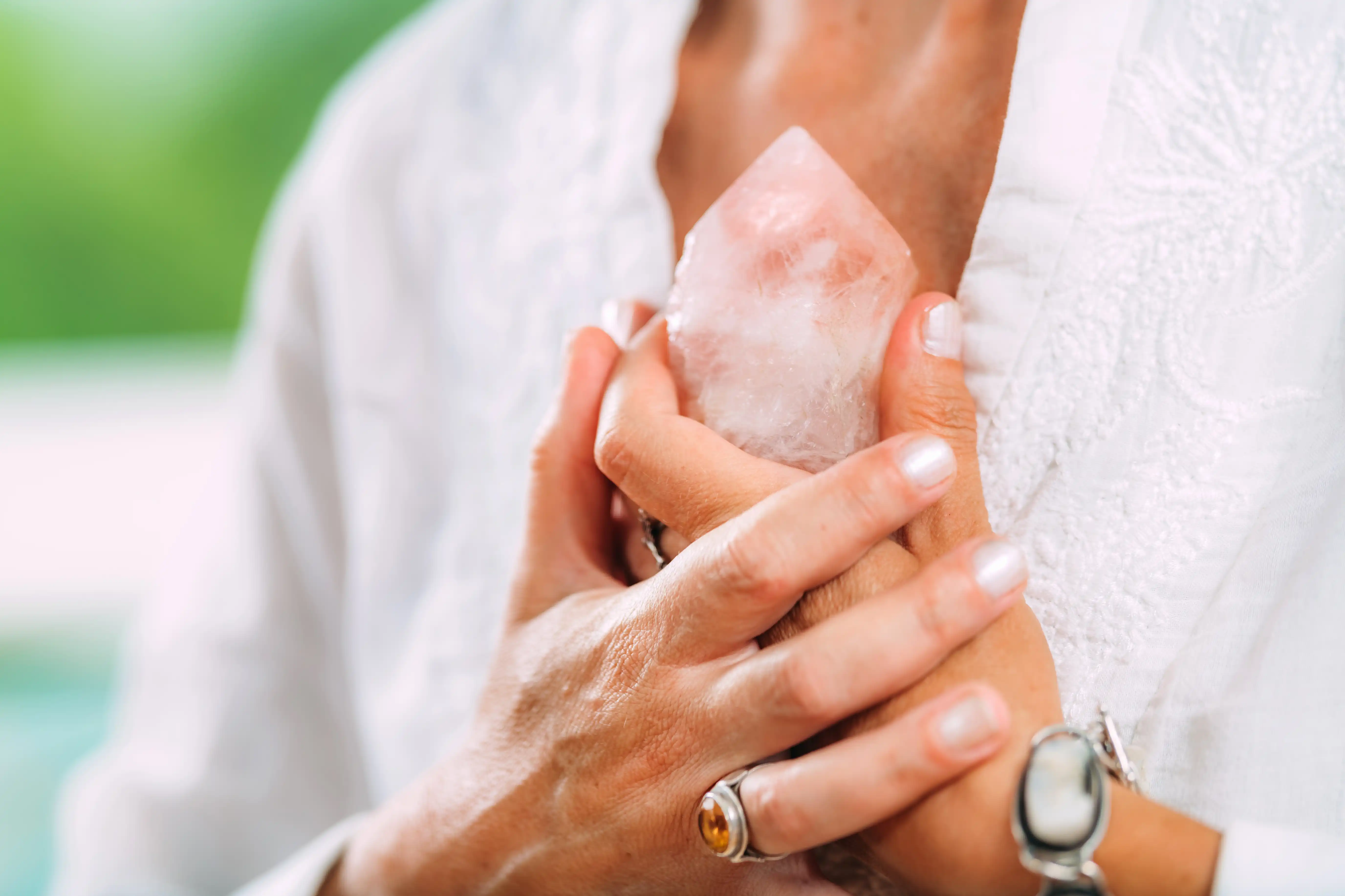 Woman holding a crystal close to her chest.