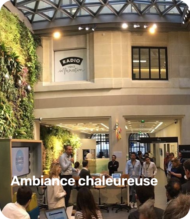 Group of people gathered in a modern indoor space with a green wall and a sign reading 'RADIO WICE Marathon.'