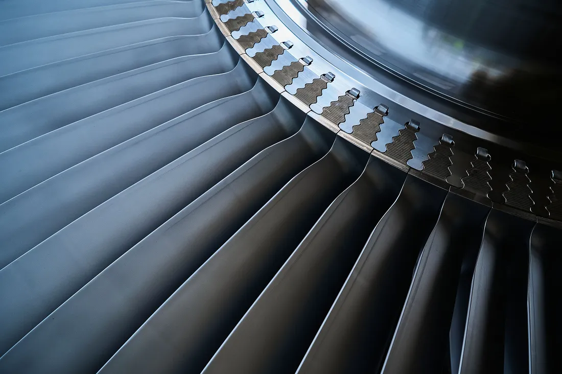 Close-up of metallic turbine blades in a jet engine.
