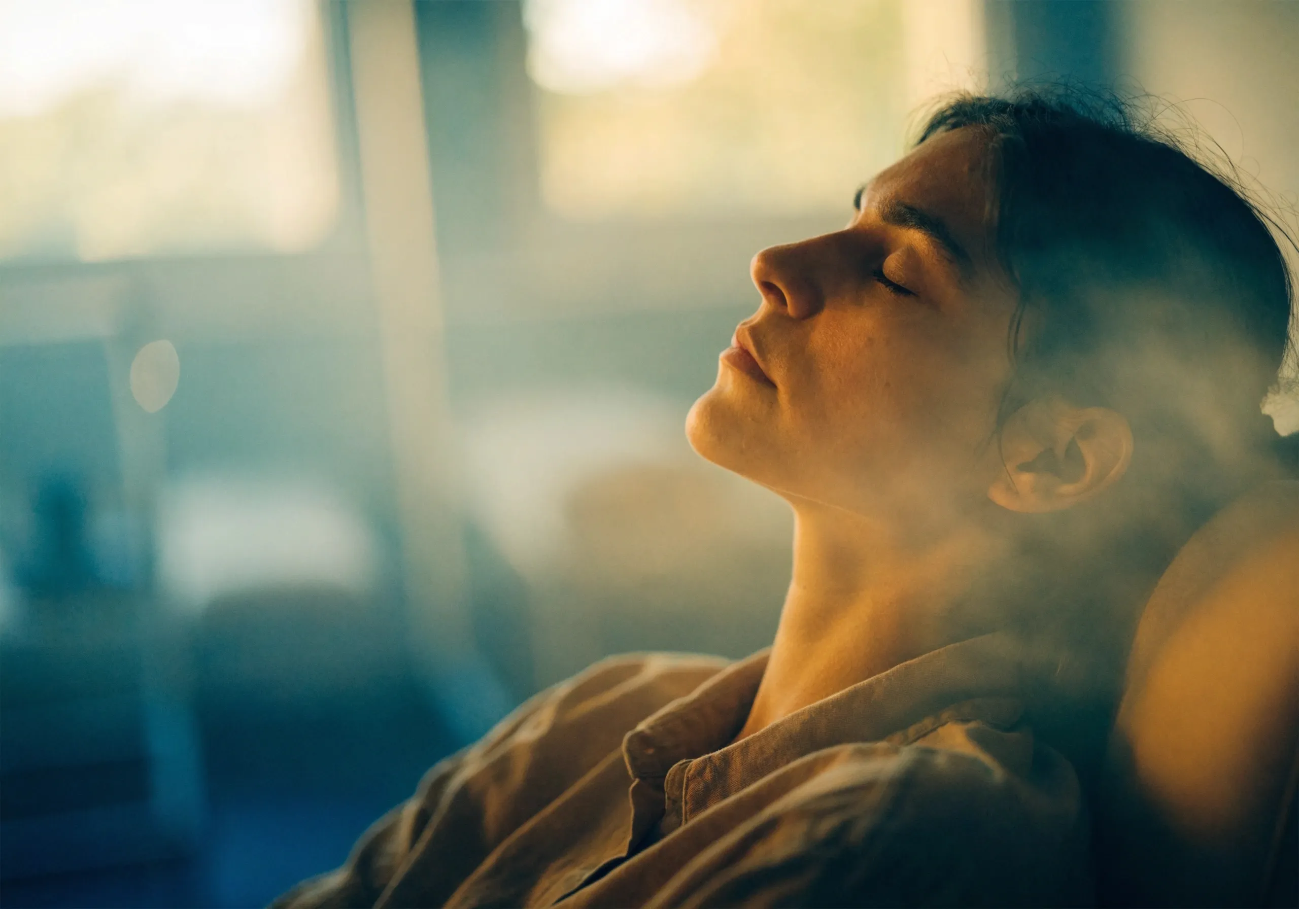 Person resting with eyes closed in a calm, sunlit room, a moment of relief from depression.