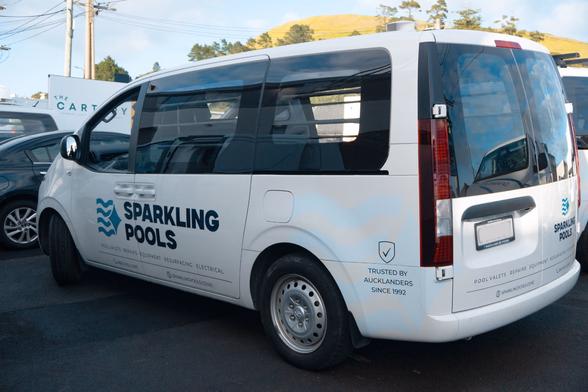 White Sparkling Pools van parked with company logo and services like pool valets and repairs.