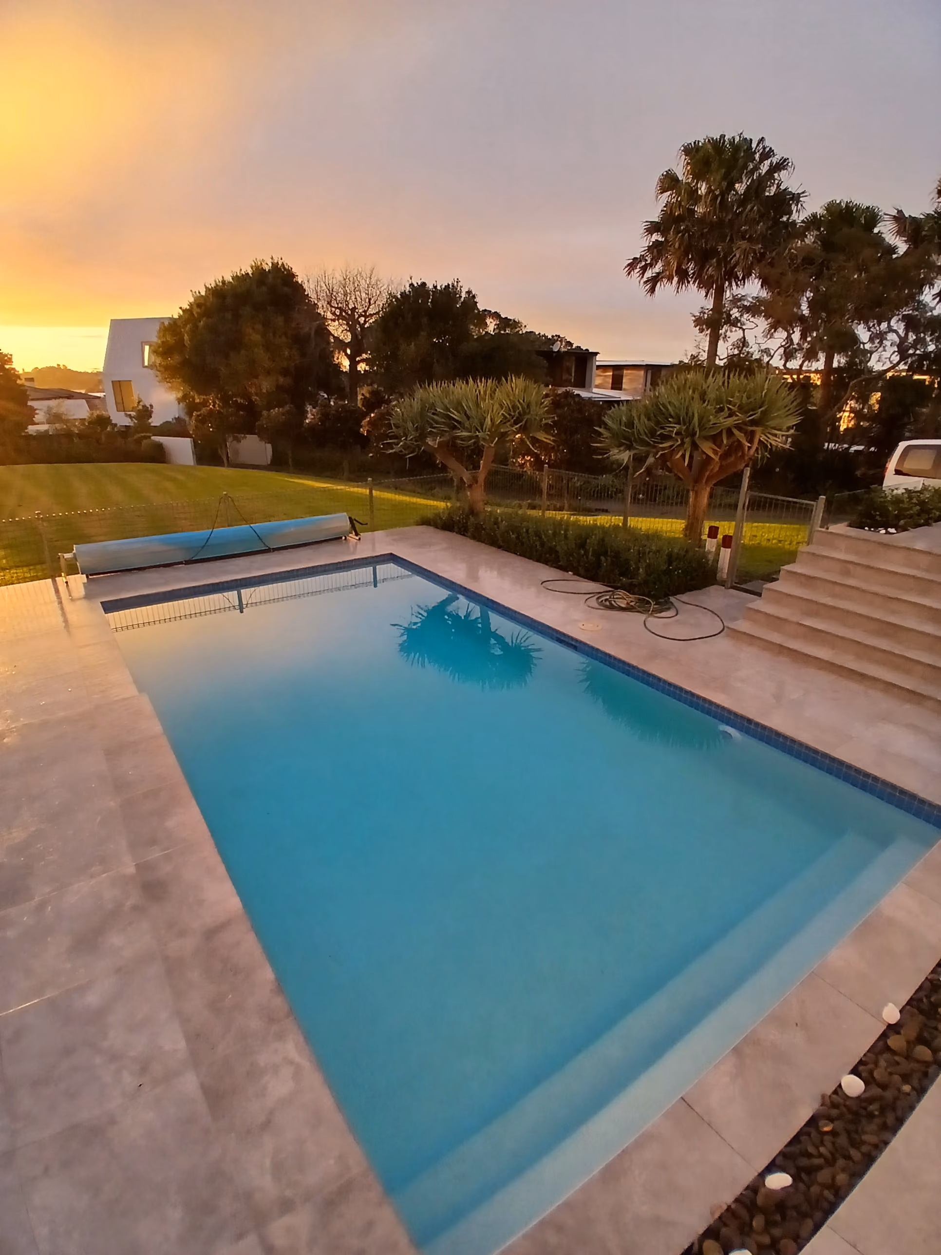 A sunrise over a blue open pool
