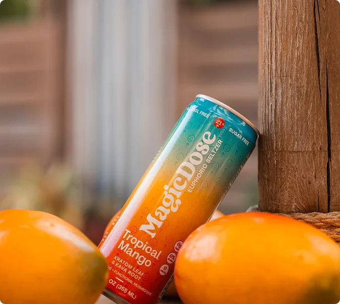 Magic Dose Tropical Mango can between two oranges