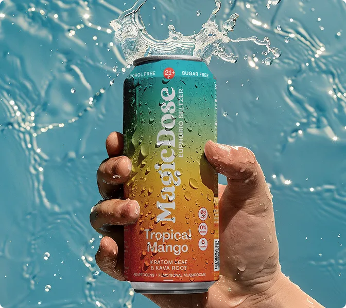 Hand holding a Magic Dose Tropical Mango can in a pool