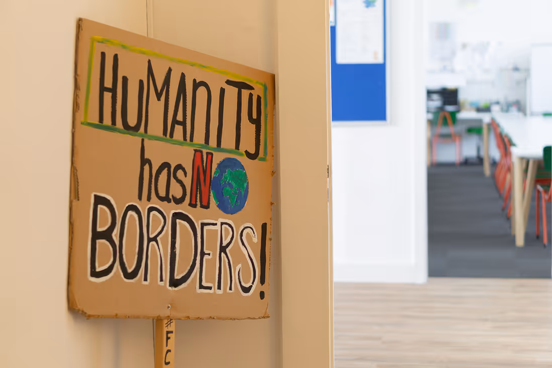 Ein Schild mit der Aufschrift "Humanity Has No Borders!" im Flur des Bildungsraums