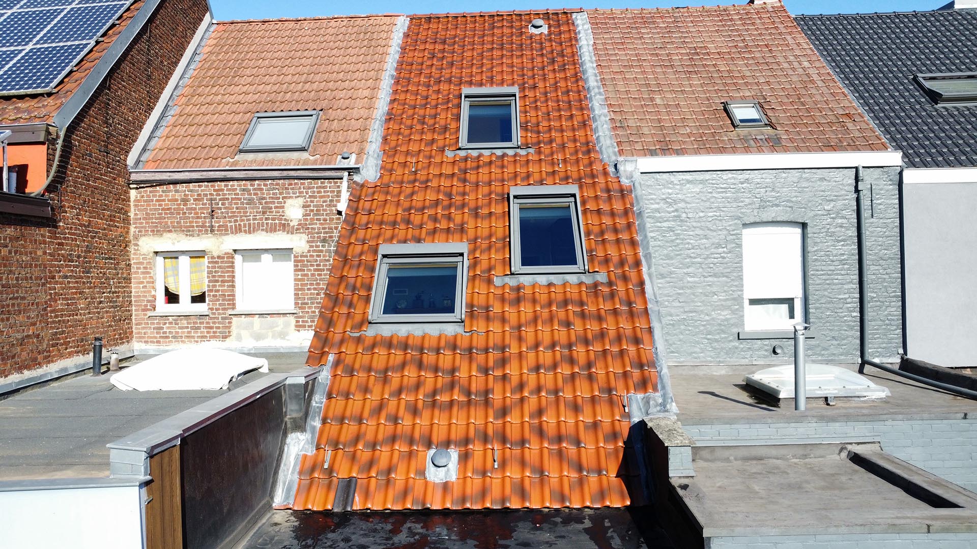 Gereinigd pannendak met dakramen in een rijwoning resultaat na dakreiniging door Mossmasters