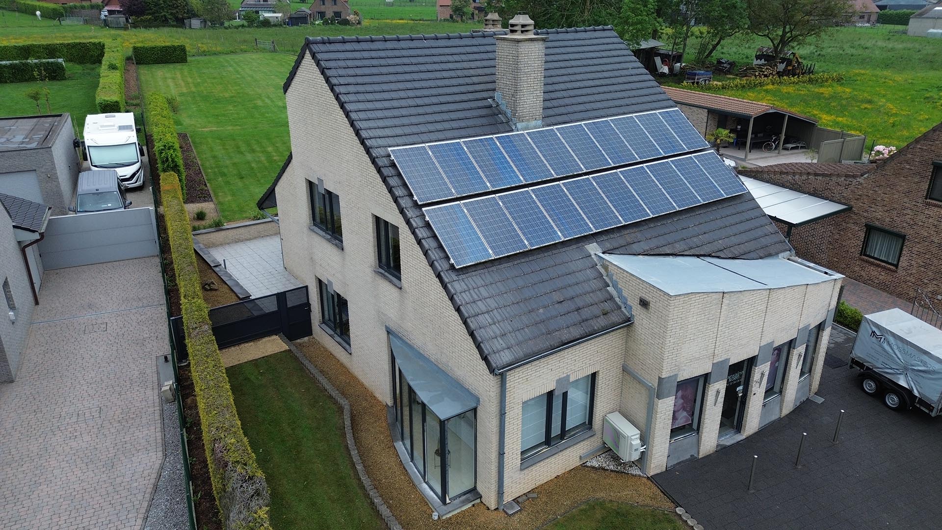 Drone-overzicht van donker pannendak met zonnepanelen bij moderne woning dakreiniging en zonnepaneelreiniging door Mossmasters