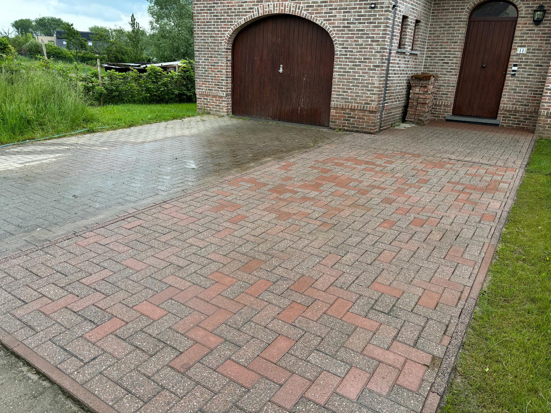 Gereinigde kasseien oprit voor een woning met garagepoort. Resultaat na mosverwijdering door Mossmasters