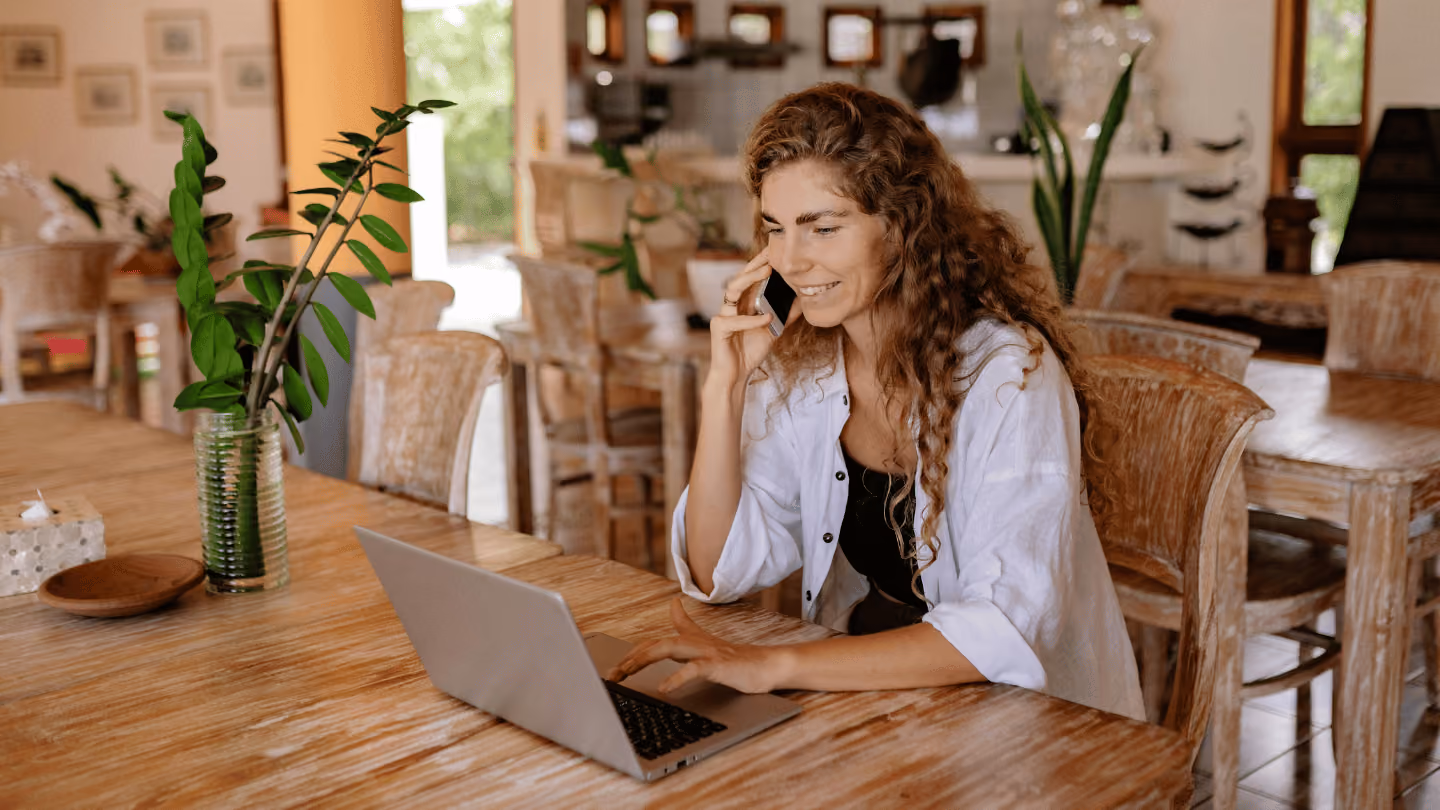 Frau die im Homeoffice vor ihrem Laptop telefoniert