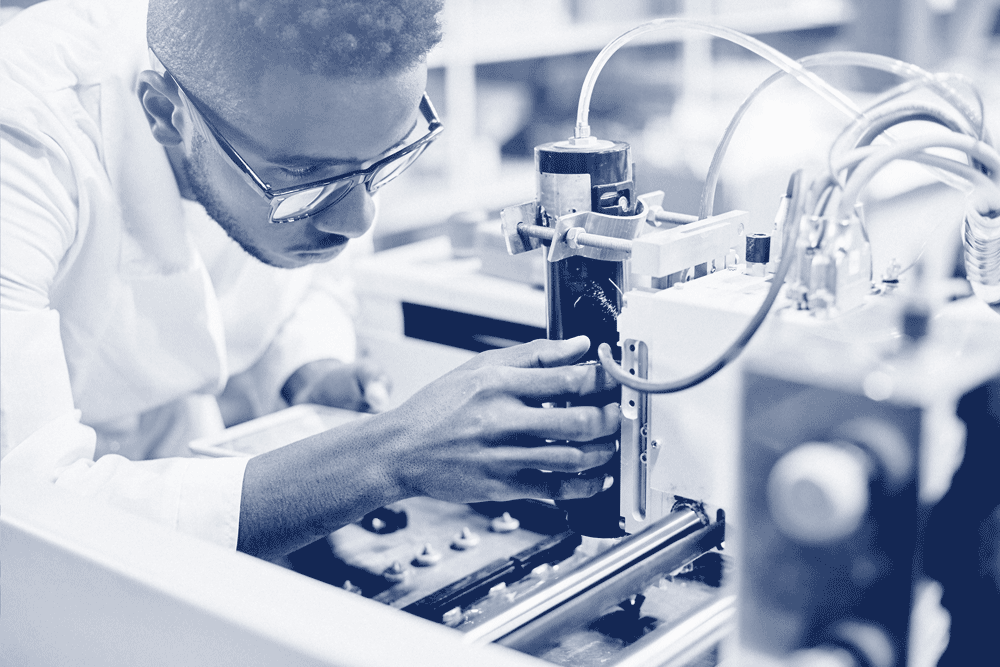 Ingénieur sur qui répare une machine complexe, illustrant le recrutement en ingénierie