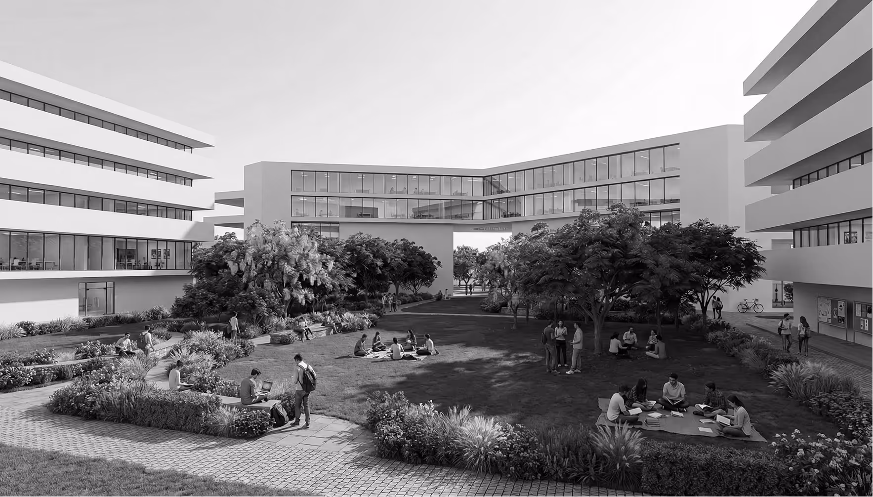 Students studying and talking in a modern campus courtyard with trees and connected buildings.