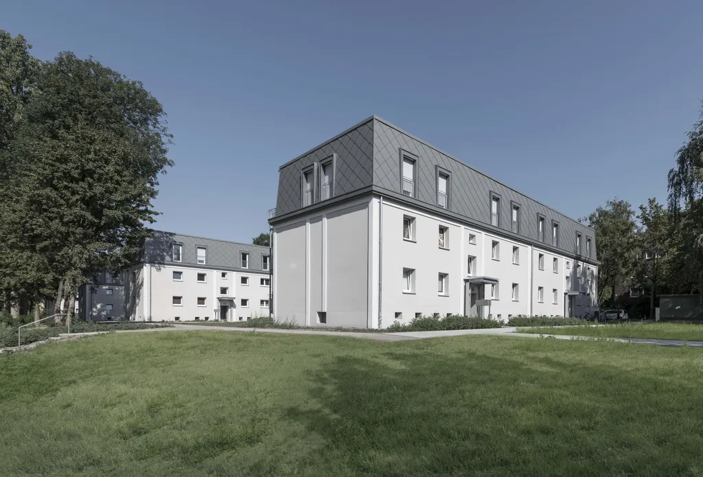 Mehrfamilienhaus mit aluminiumverkleidetem dachgeschoss
