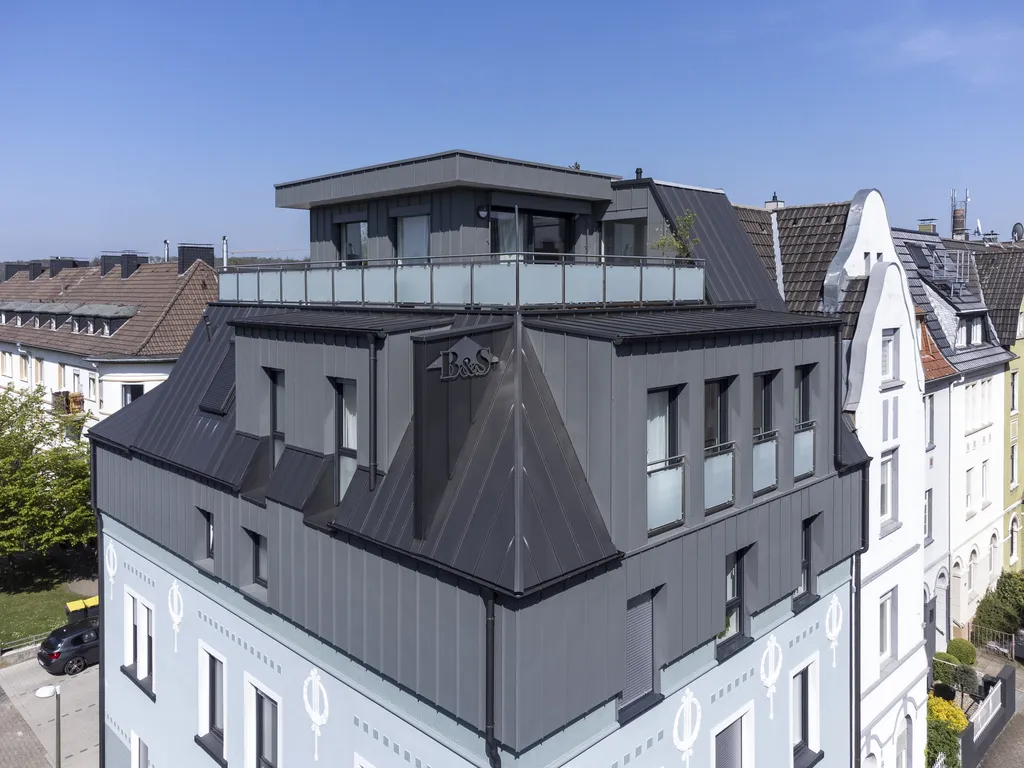 Mehrfamilienhaus mit dunklem aluminium falzdach