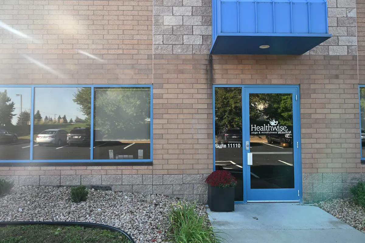Exterior of Maple Grove Studio: brick building with glass door and landscaping