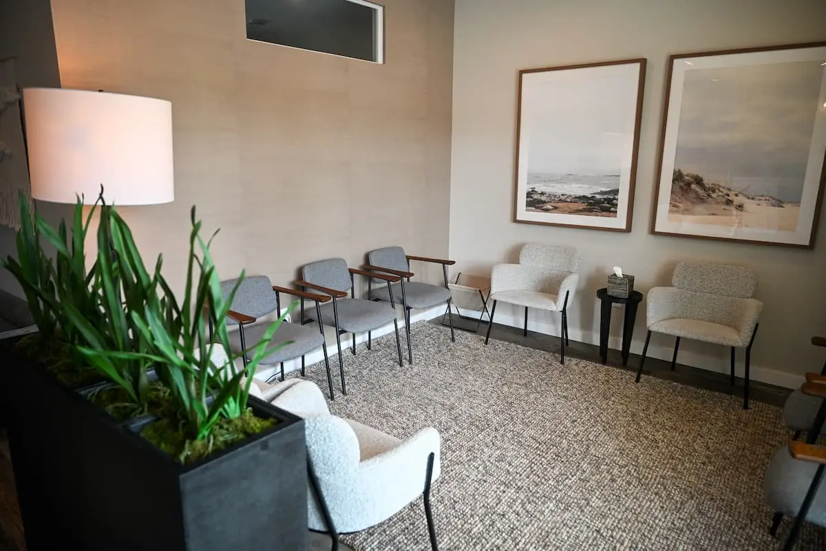 Plymouth office waiting room with couches and chairs and paintings on the walls