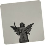 Black and white photograph of an angel statue with wings against a gray sky.