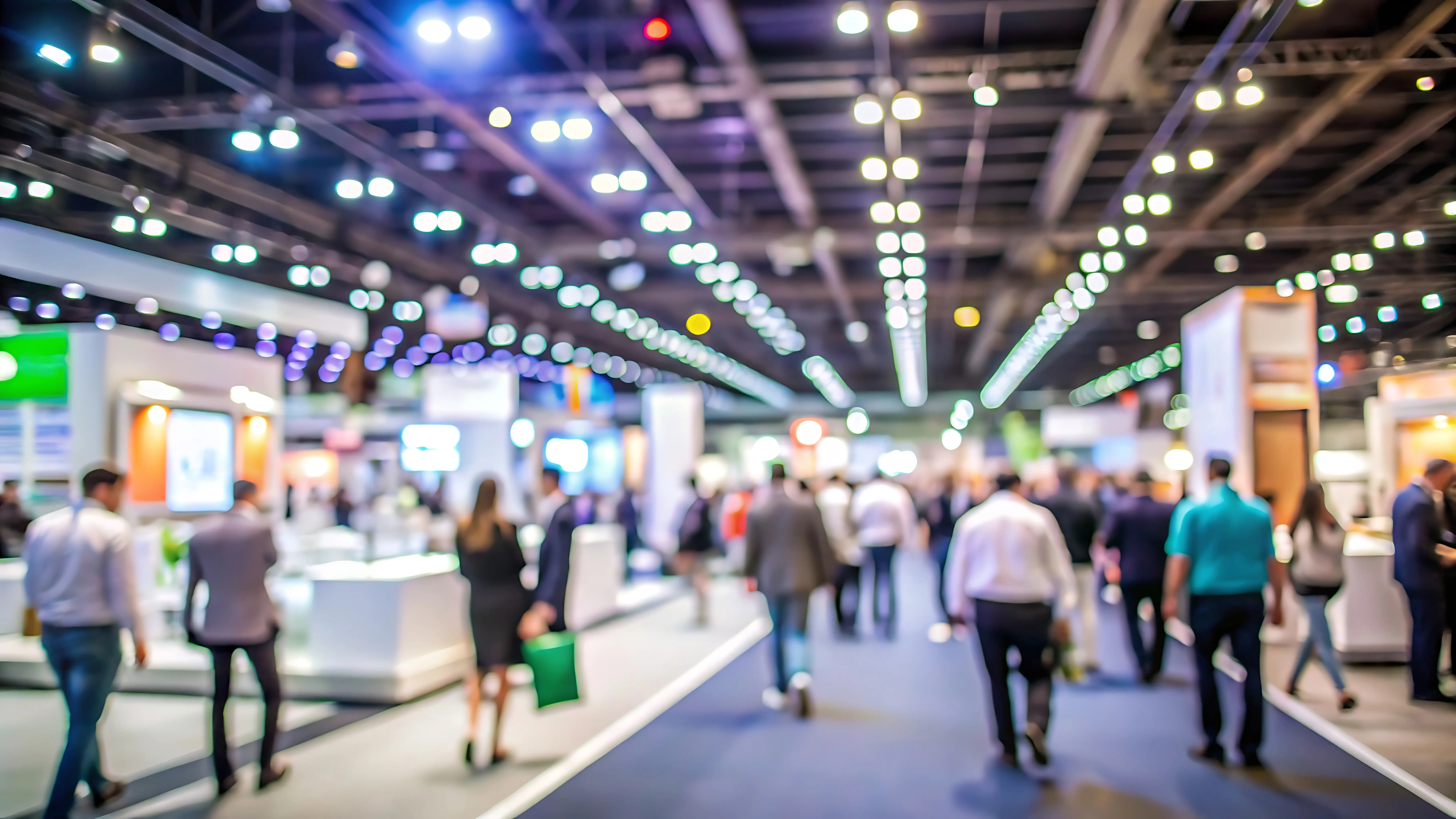 Blurred view of attendees walking through a trade show exhibit hall