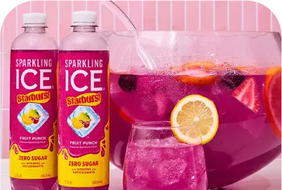 Two bottles of Sparkling Ice Starburst fruit punch with a glass and punch bowl filled with pink drink and fruit slices.