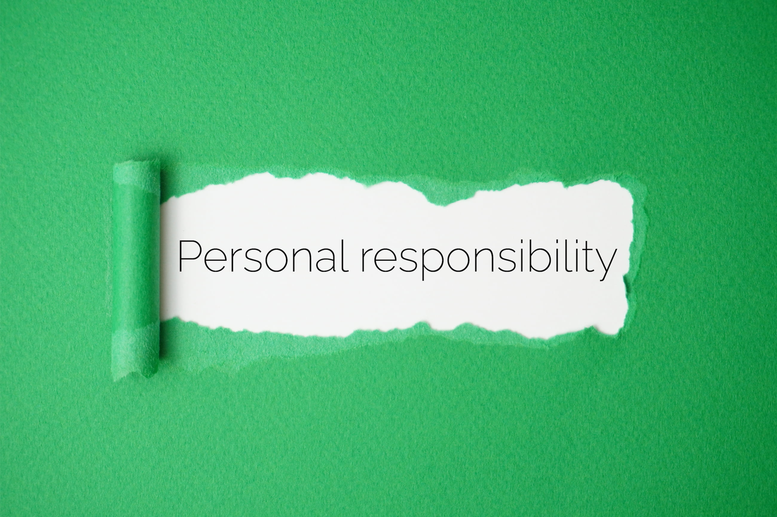 Ripped green paper revealing white background with the text Personal responsibility.