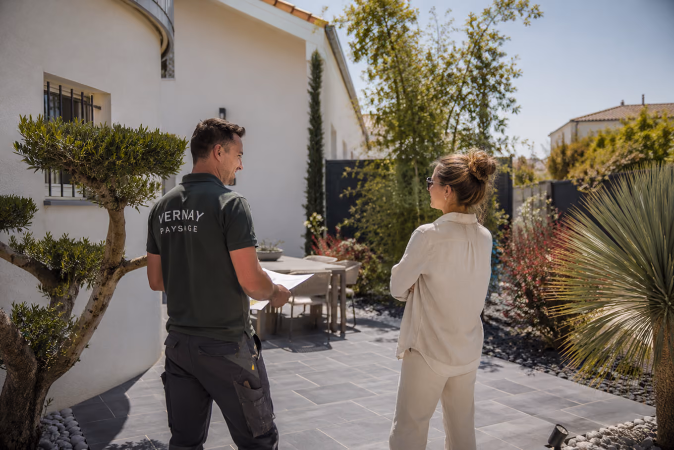Paysagiste de Vernay Paysage présentant un projet finalisé de terrasse à une cliente