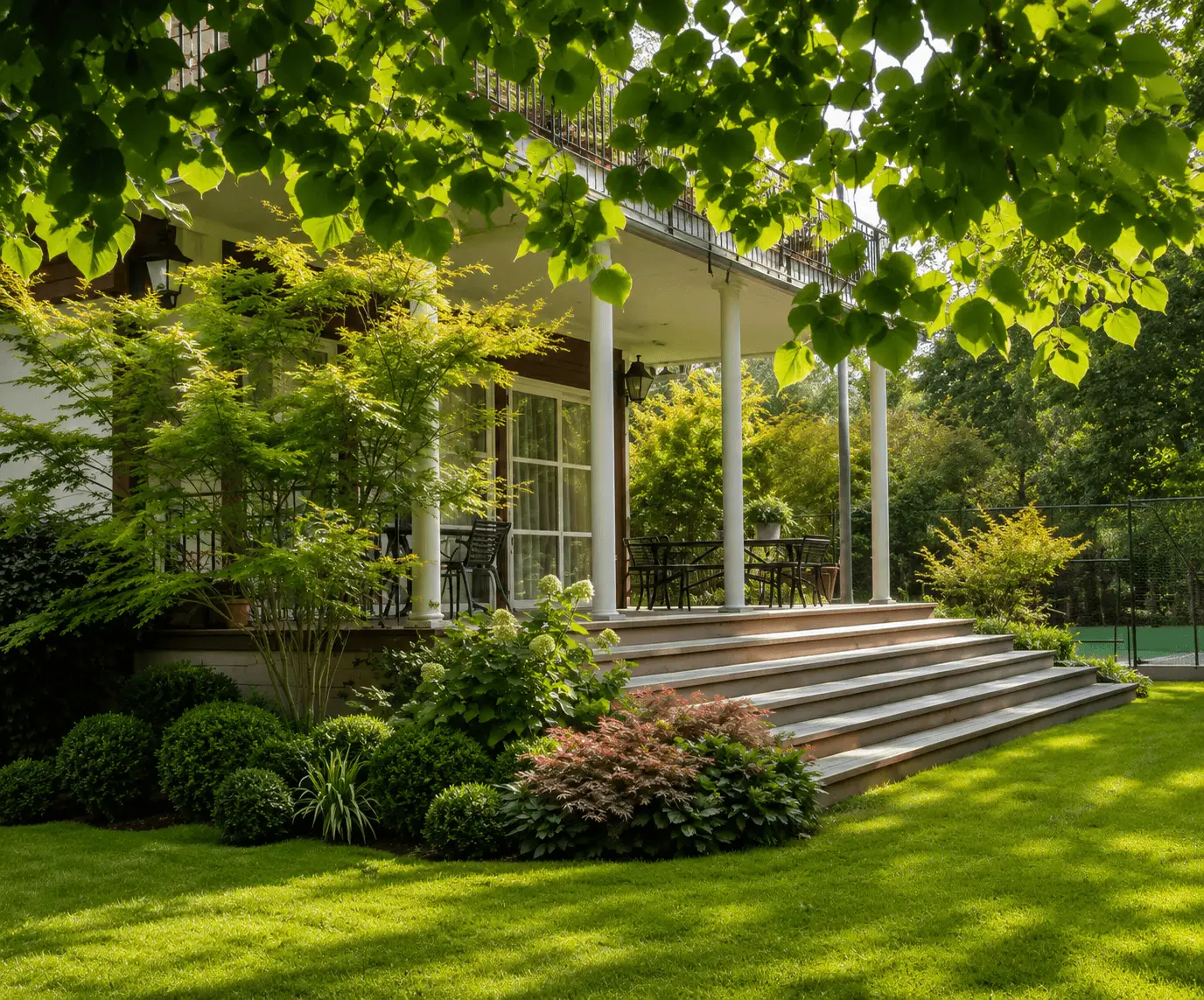 Jardin entretenu avec pelouse et arbres après une intervention de Vernay Paysage.