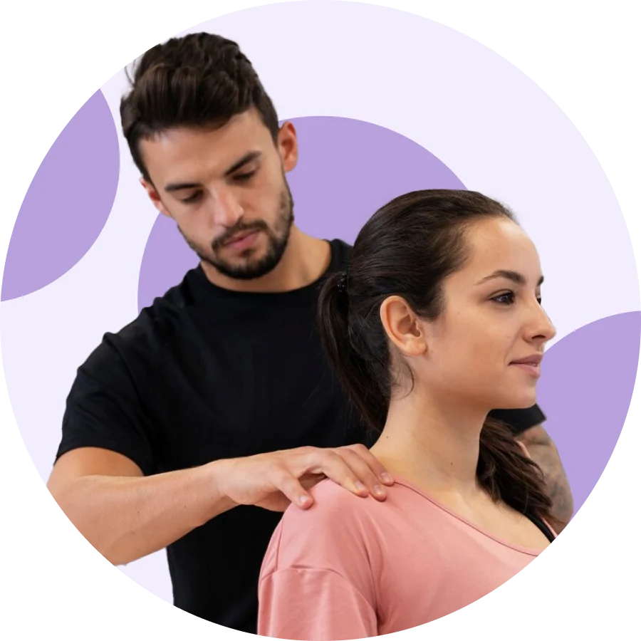 Physical therapist examining a seated patient's shoulders and upper back